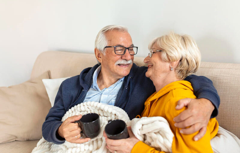 abuelos sentados en el sofá con una manta